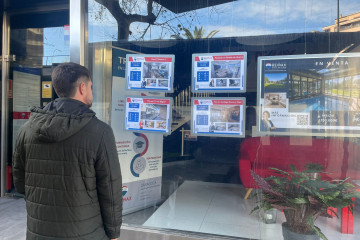 Joven adulto mirando pisos en venta.