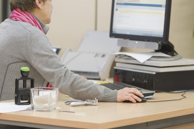 Archivo - Una funcionaria en su puesto de trabajo