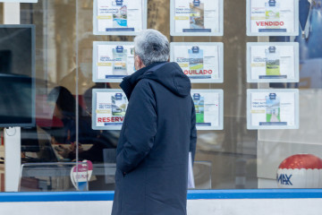Archivo - Un hombre observa los anuncios de una inmobiliaria