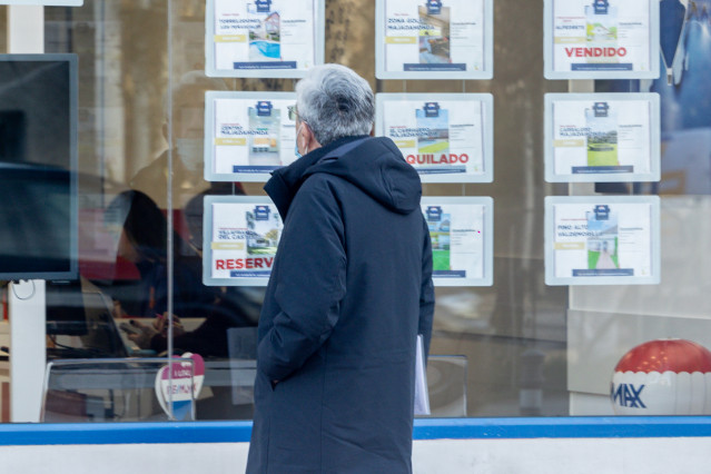 Archivo - Un hombre observa los anuncios de una inmobiliaria