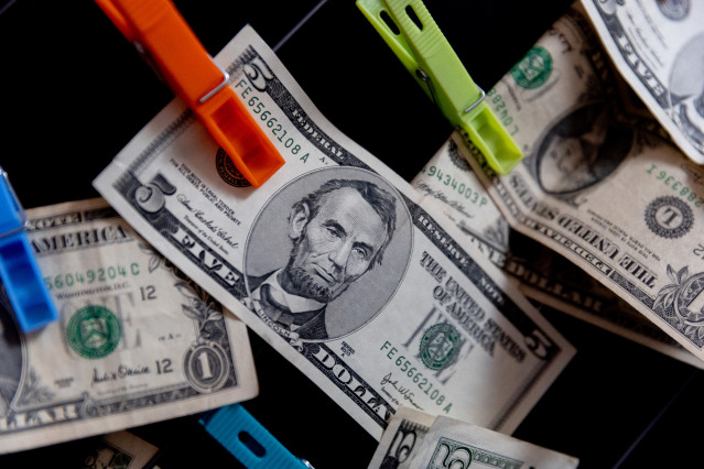 Archivo - Varios dólares sujetos con pinzas, a 9 de enero de 2024, en Madrid (España). Durante el 2023, el 65% de la población hizo uso del efectivo para el pago principal de compras en comercios físicos en España, según revela una de las principales conc