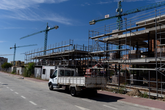 Archivo - Un camión delante de las obras de vivienda nueva.