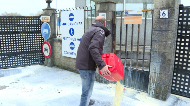 Manifestantes rocían con bidones de leche la puerta de entrada de la Fábrica Leche Celta.