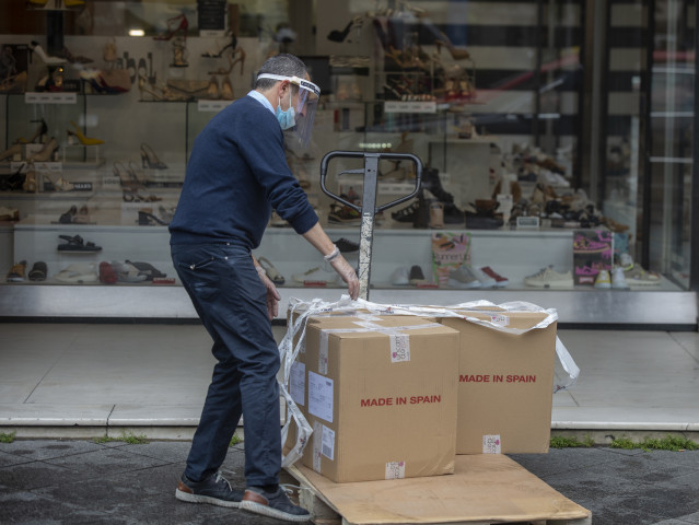 Archivo - Un trabajador descarga mercancía en una zapatería, durante el segundo día de la fase 1 del plan de desescalada que ha elaborado el Gobierno de España. En Sevilla, (Andalucía, España), a 12 de mayo de 2020.
