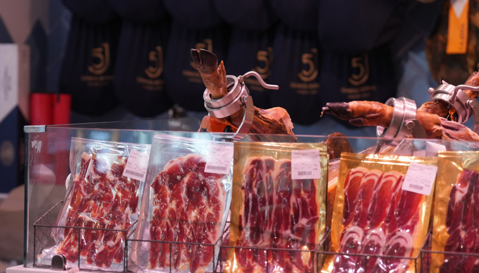 Archivo - Jamón serrano expuestos en un mercado en Barcelona.