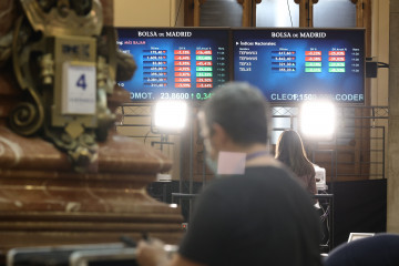 Archivo - Un hombre delante de dos paneles con valores del Ibex 35, en el Palacio de la Bolsa, a 4 de febrero de 2022, en Madrid (España).