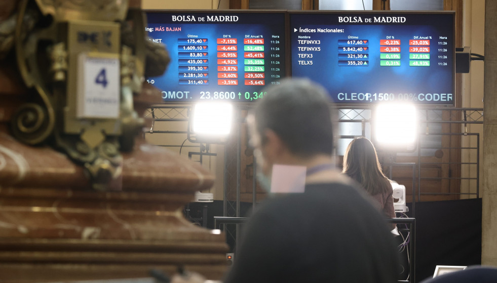 Archivo - Un hombre delante de dos paneles con valores del Ibex 35, en el Palacio de la Bolsa, a 4 de febrero de 2022, en Madrid (España).