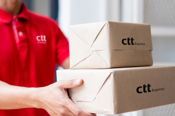 Archivo - Un trabajador de CTT Express entrega unos paquetes