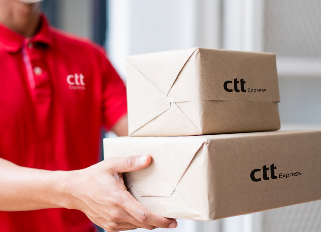 Archivo - Un trabajador de CTT Express entrega unos paquetes