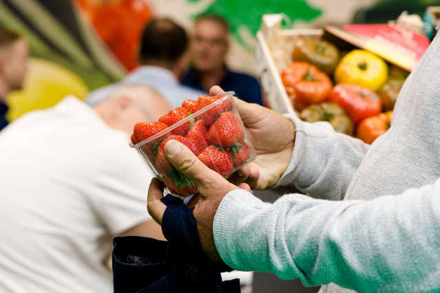 Archivo - Un hombre comprando un cuenco de fresas