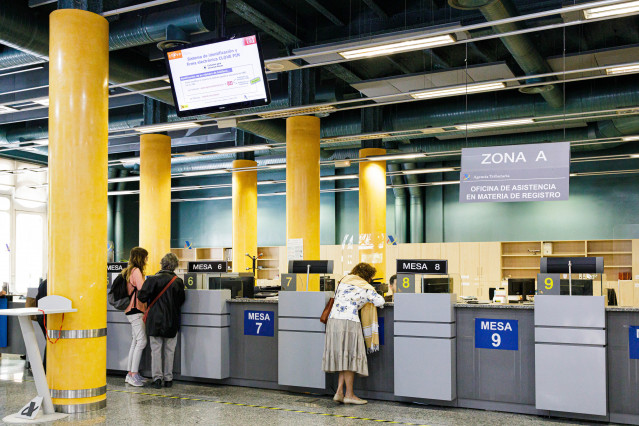 Archivo - Varias personas en una oficina de la Agencia Tributaria