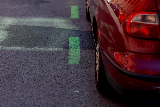 Archivo - Un coche aparcado en una calle con zona verde.