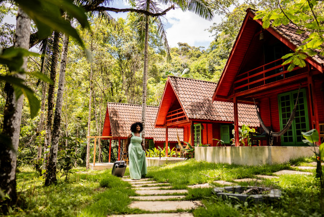 Archivo - Mid adult tourist woman walking with luggage and arriving on inn.