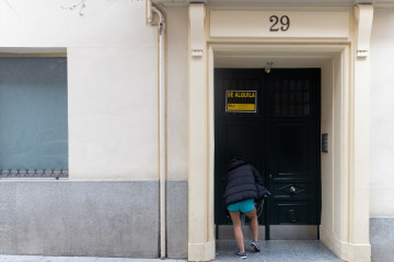 Archivo - (Foto de ARCHIVO) Una persona pasa a un edificio donde hay un cartel de ‘Se alquila’