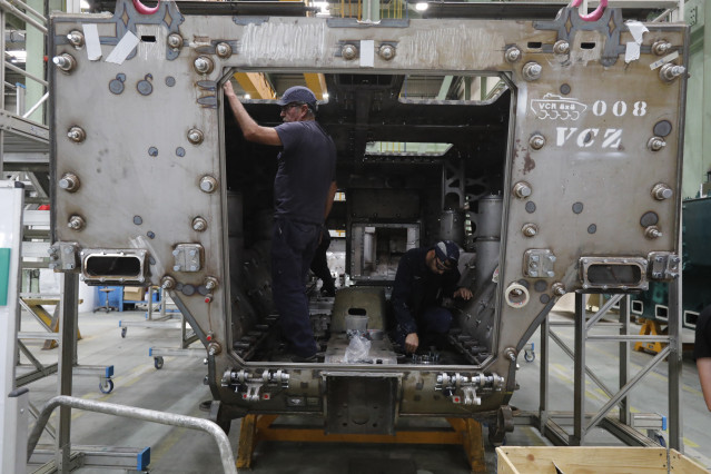 Archivo - Dos operarios trabajando en una fábrica
