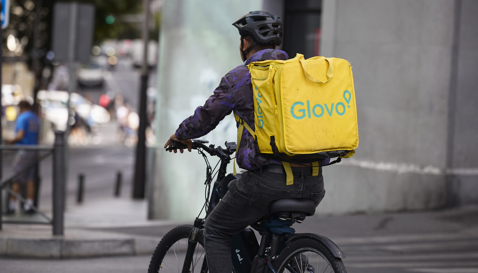Archivo - Un repartidor de Glovo en bicicleta por una calle de Madrid
