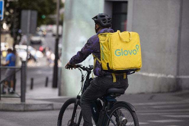Archivo - Un repartidor de Glovo en bicicleta por una calle de Madrid