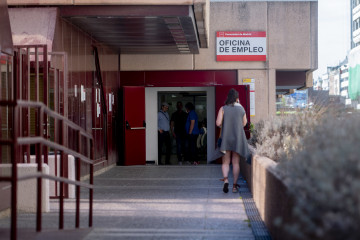 Archivo - Una mujer en la puerta de una oficina de empleo