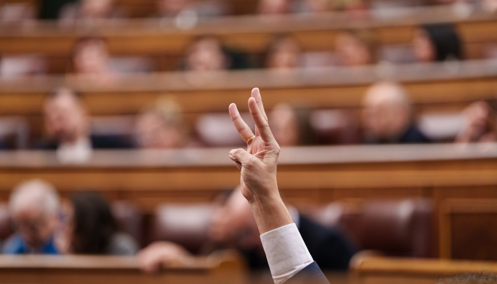 Archivo - Un diputado marca el número de votación durante una sesión plenaria en el Congreso
