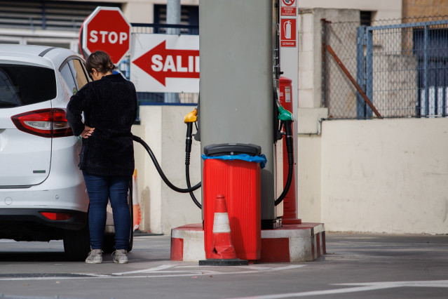 Archivo - Un mujer reposta carburante en una gasolinera