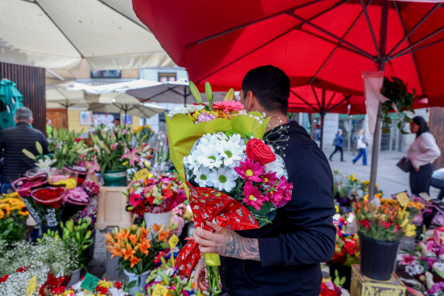 Archivo - Un hombre compra dos ramos de flores en un puesto del Mercado de Flores de Tirso de Molina, a 5 de mayo de 2023, en Madrid (España). Las flores para regalar el Día de la Madre el primer domingo de mayo es una de las tradiciones más populares en