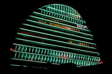 Archivo - El edificio La Vela de BBVA iluminado de color verde.