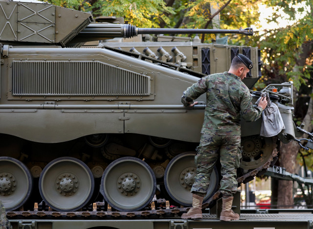 Archivo - Un militar del Ejército de Tierra limpian un tanque antes el acto solemne de homenaje a la bandera nacional y desfile militar en el Día de la Hispanidad, a 12 de octubre de 2022, en Madrid (España).