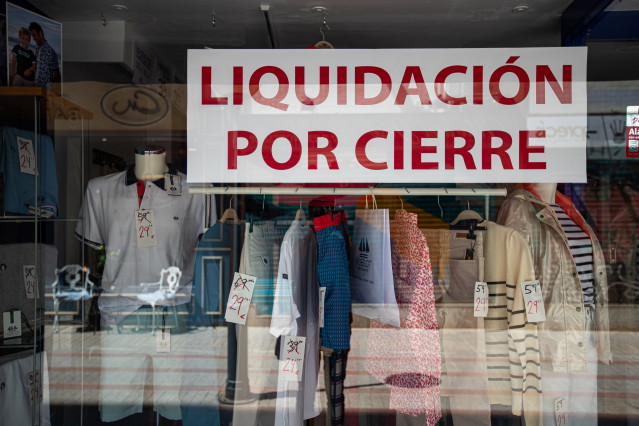Archivo - El escaparate de un comercio anunciando su liquidación por cierre
