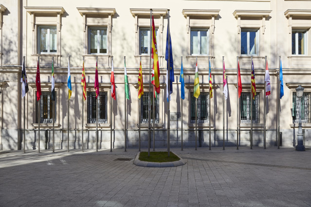 Archivo - Banderas de las Comunidades Autónomas frente a la fachada del Palacio del Senado.