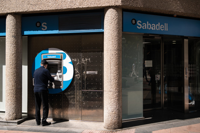 Archivo - Un hombre en el cajero de la entidad bancaria de Sabadell que ha sido atracada, en la calle Núñez de Balboa, a 21 de abril de 2023, en Madrid (España).