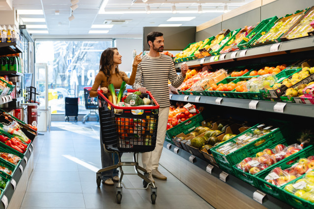 Archivo - Dos personas comprando fruta en un supermercado