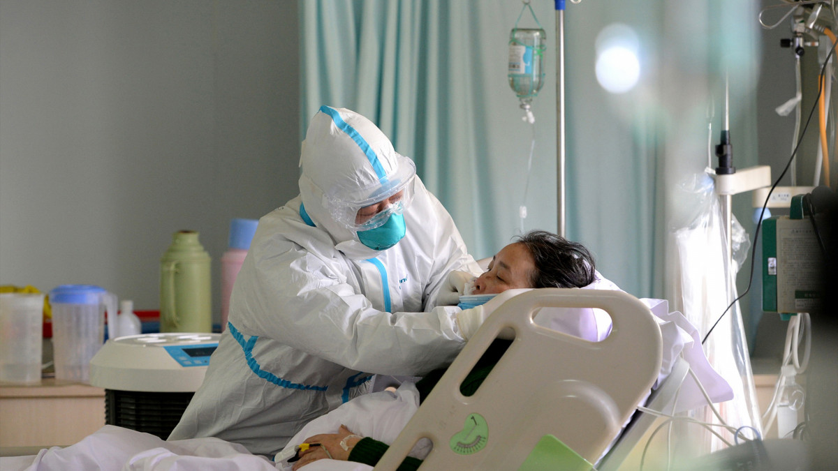 Un médico militar atiende a un paciente enfermo de coronavirus en la unidad de cuidados intensivos, en China, a 1 de febrero de 2020.