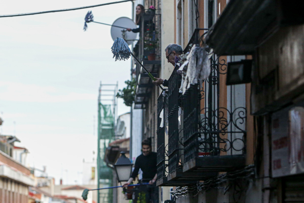 Vecinos del barrio madrileño de Lavapiés, realizan la 'Fregonada de Lavapiés', un gesto que consiste en agitar fregonas desde sus balcones para 