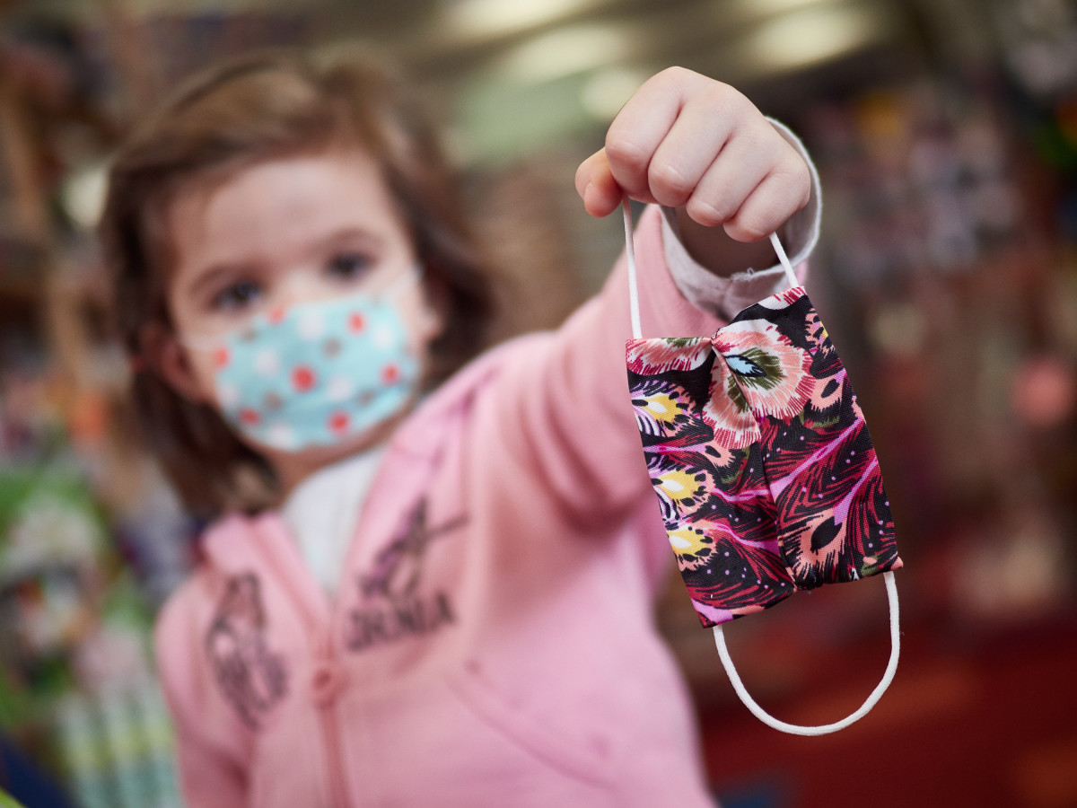 Una niña muestra una mascarilla infantil mientras sale a la calle en Pamplona a finales de abril.