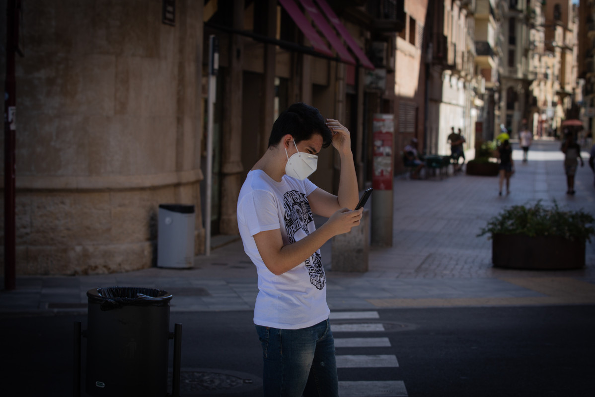 Un joven protegido con mascarilla camina por una calle del centro de Lleida, capital de la comarca del Segrià, en Lleida, Catalunya (España), a 6 de julio de 2020.
