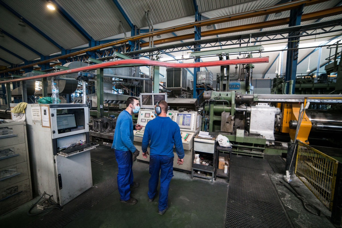 Varios trabajadores durante su jornada laboral en la empresa Extrusión Toledo, innovadora en la fabricación de perfiles metálicos, que ha creado y patentado un modelo de separadores en restaurantes durante la pandemia de Covid-19, en Toledo, Castilla-La M