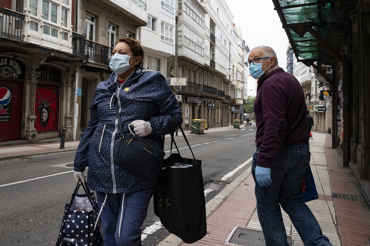 Transeúntes pasean con mascarillas por A Coruña en el día 41 del estado de alarma por la crisis sanitaria del Covid-19 donde tan solo están permitidos por el momento los desplazamientos para empleados de servicios esenciales, aquellos que no puedan teletr