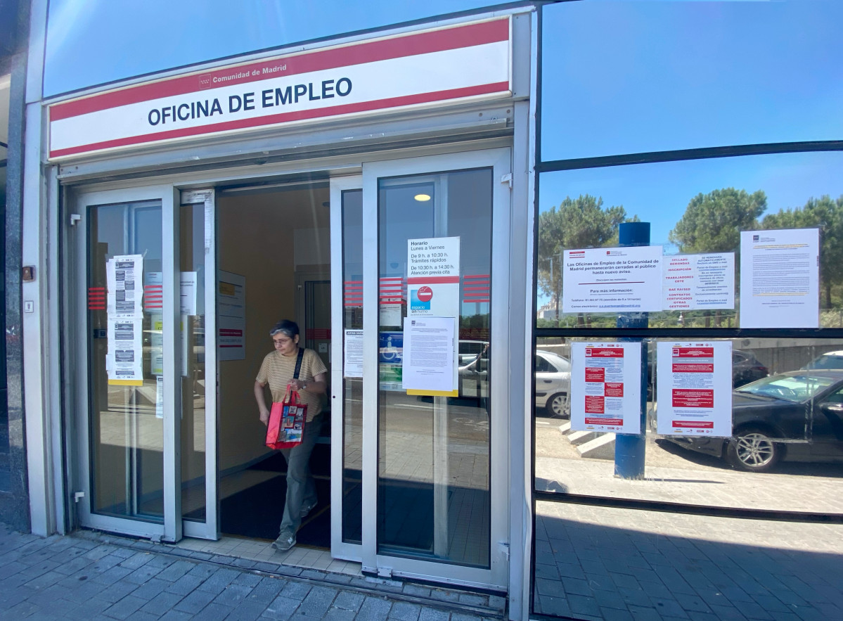 Una mujer sale por la puerta de una oficina del SEPE