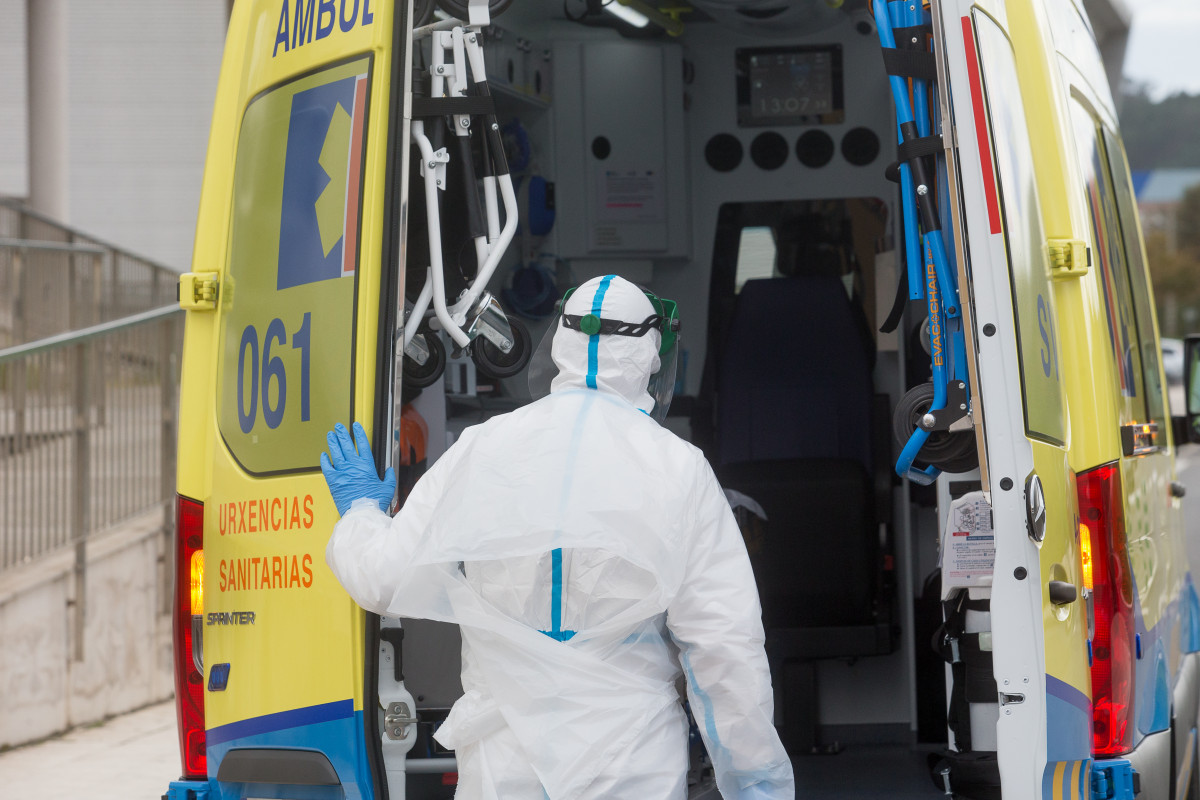 Un trabajador sanitario totalmente protegido cierra la puerta de una ambulancia tras recoger a un anciano de la residencia de ancianos de San Cibrao donde se ha originado un brote de Covid-19, en San Cibrao, Lugo.