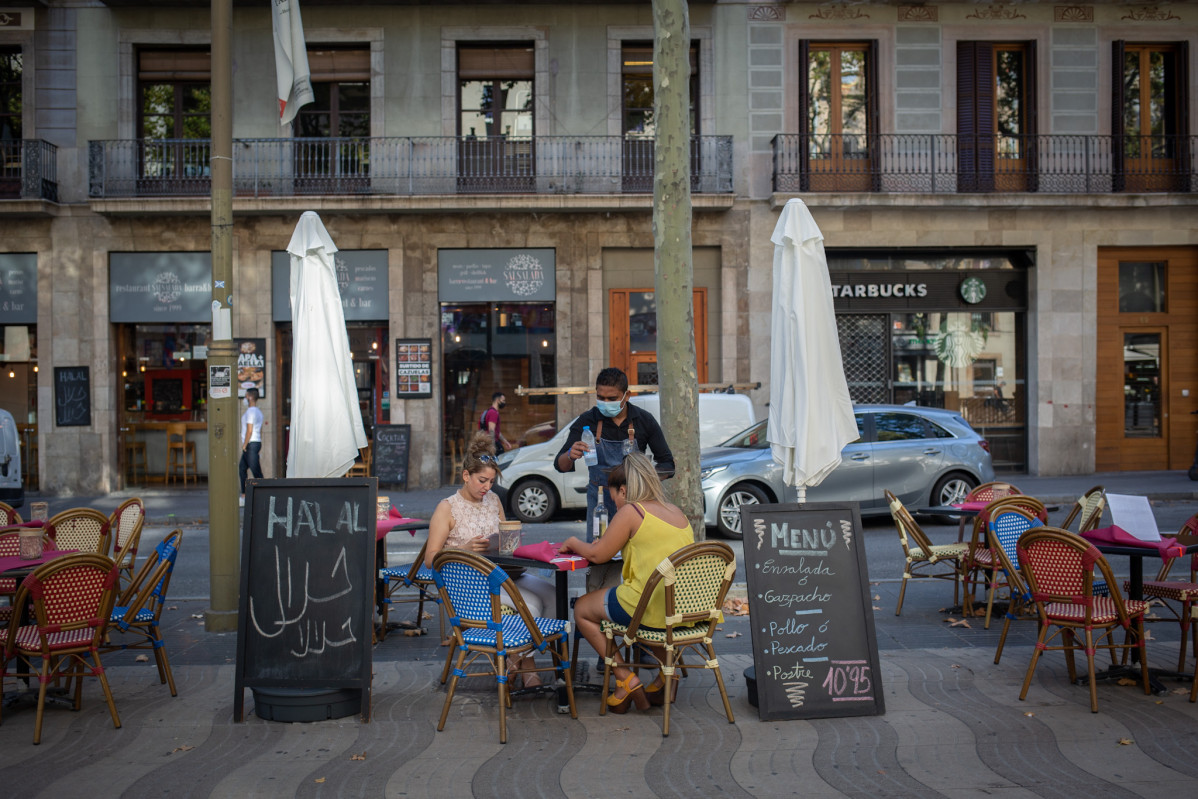 Dues dones mengen en la terrassa d'un bar a Barcelona, Catalunya (Espanya) a 14 d'octubre de 2020.