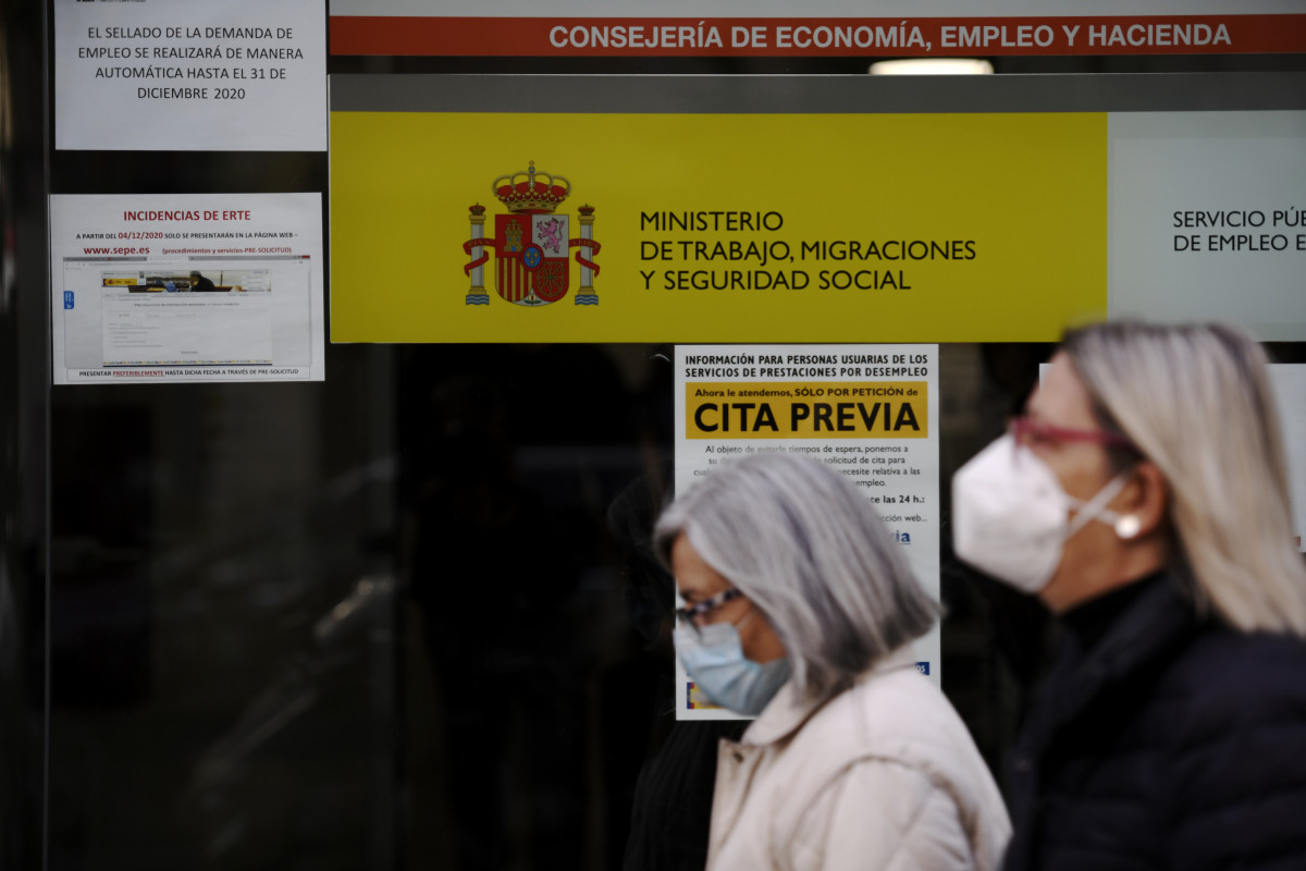 Dos mujeres pasan por la puerta de una oficina de empleo, SEPE (antiguo INEM) horas después de conocer los datos del paro de noviembre, en Madrid (España), a 2 de diciembre de 2020.