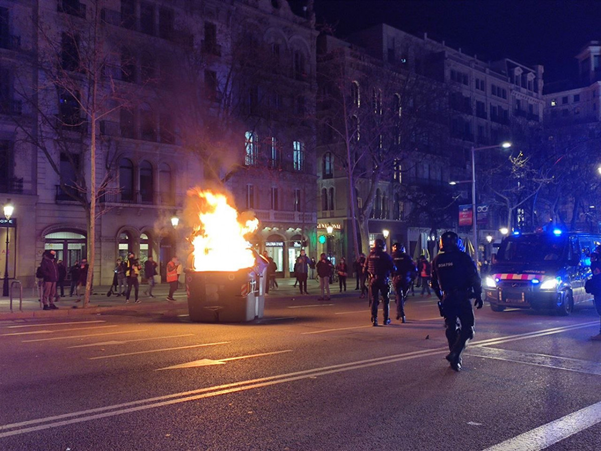 Queman un contenedor en el paseo de Gràcia de Barcelona durante la manifestación en apoyo a Pablo Hasel