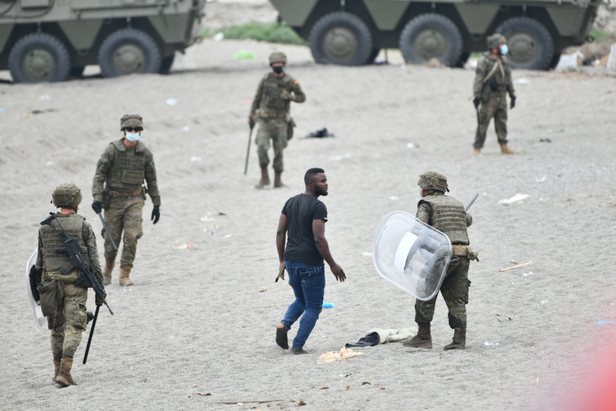 Militares del ejército español efectúan una devolución en caliente a uno de los migrantes que han entrado en Ceuta procedente de Marruecos.
