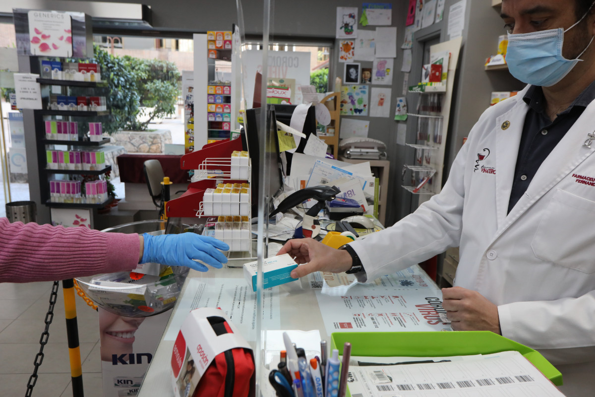 Un farmacéutico vende una caja de Paracetamol en su farmacia durante el segundo mes de confinamiento, en Madrid (España) a 20 de abril de 2020.
