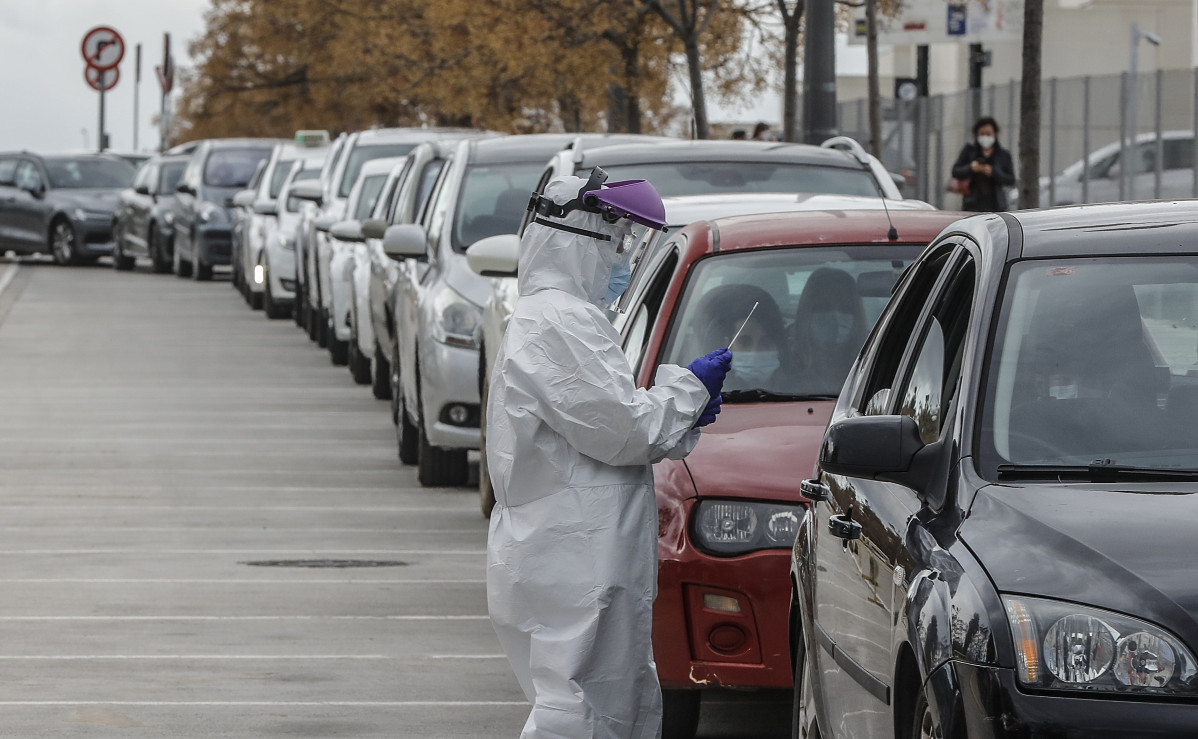 Archivo - Un sanitario realiza una prueba PCR a una persona desde su vehículo para la detección del coronavirus a las puertas del Hospital de Campaña próximo al de La Fe, en Valencia (España), a 25 de enero de 2021. Los contagios de COVID-19 en la Comunid