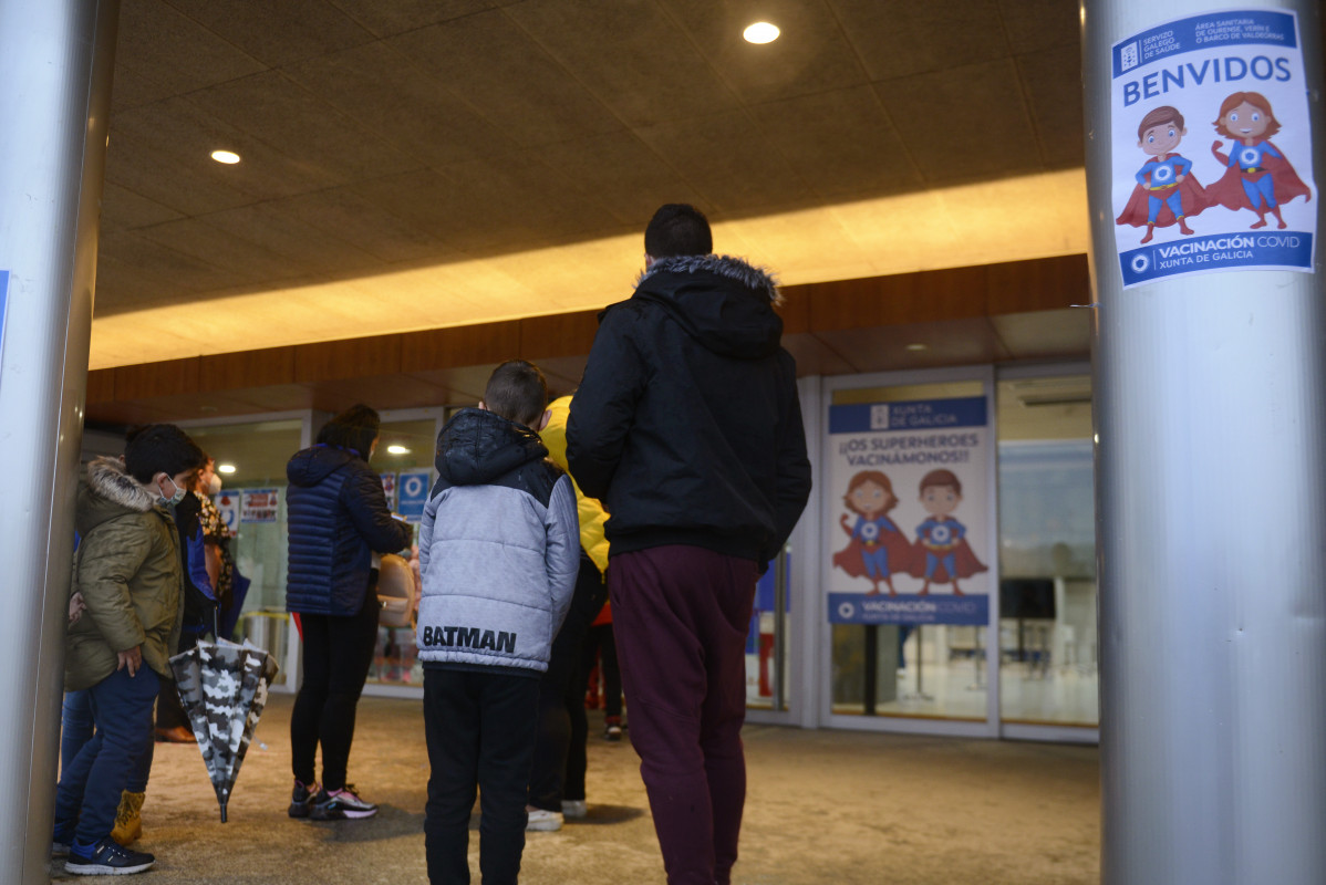 Varios niños acompañados de sus padres, a su llegada al recinto ferial Expourense para ser vacunados