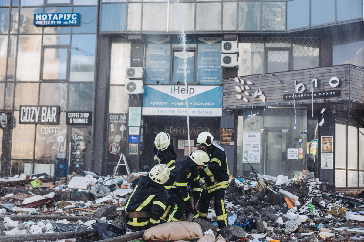Bomberos intentan apagar un fuego de un edificio civil bombardeado, en una zona residencial en Kiev (Ucrania).