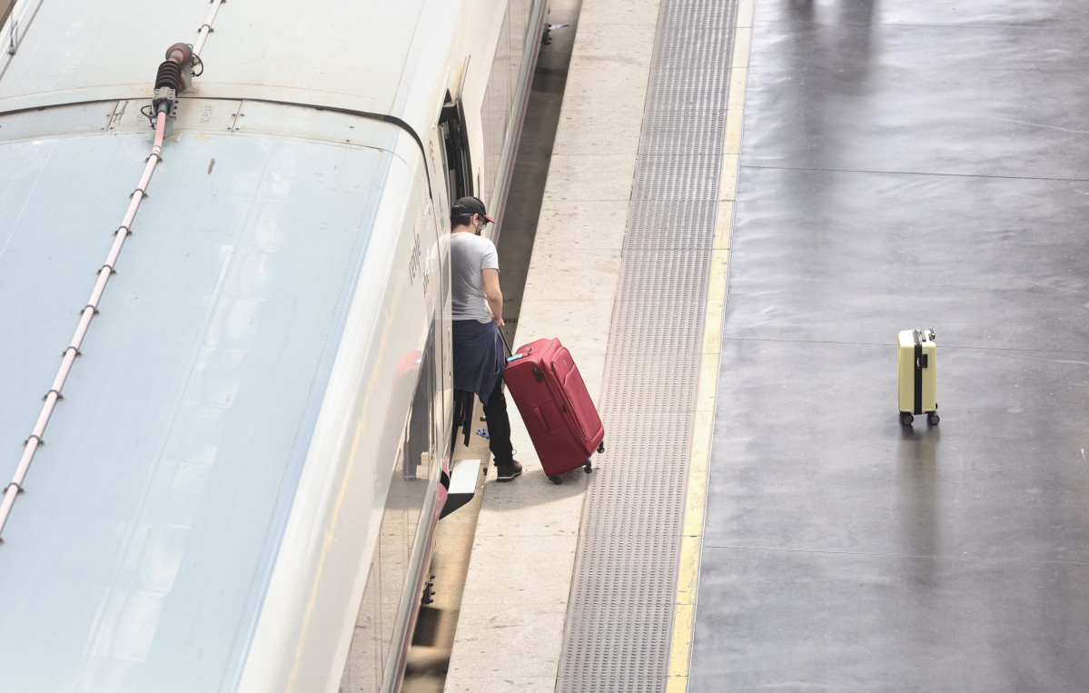 Un hombre con una maleta sube a un tren en la Estación Puerta de Atocha, a 13 de abril de 2022, en Madrid (España). Hoy, Miércoles Santo, arranca la segunda fase de la Operación Salida de la Semana Santa 2022, una jornada marcada por el inicio de un puent