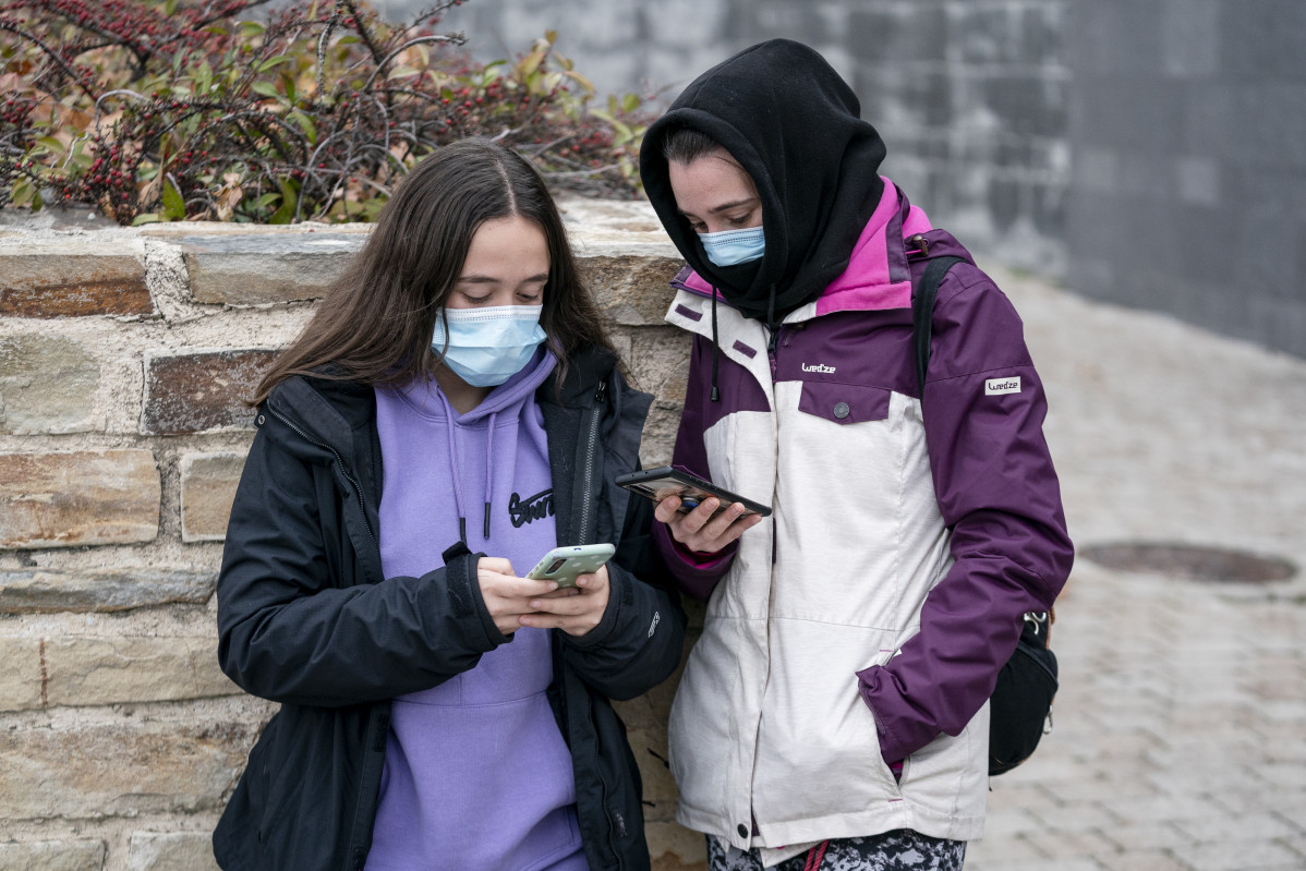 EuropaPress 4162942 dos chicas mascarilla mirando moviles dia antes vigor obligatoriedad usar